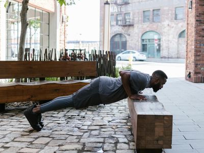 Side view of a man executing a controlled push-up with perfect form.